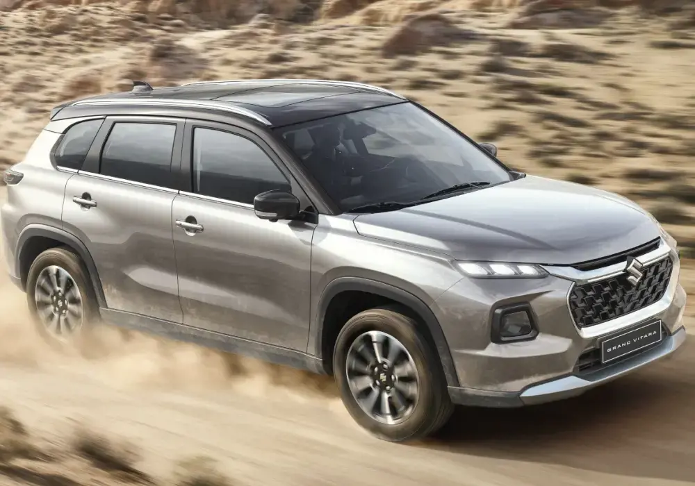 Suzuki Grand Vitara SUV plateado conduciendo por el desierto.